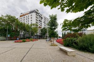 a park with a bench in front of a building at Miejsko Tu - Opera #119 in Olsztyn