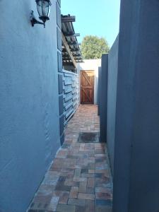 a hallway with a door and a brick walkway at Nais cottage in Cape Town