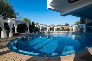 una gran piscina con sillas y sombrillas en Meiser Vital Hotel, en Fichtenau