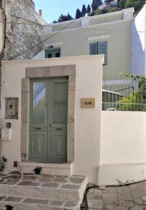 a white house with a green door at Yalitzi in Symi