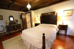 een slaapkamer met een groot wit bed in een kamer bij Casa das Paredes in Fafe