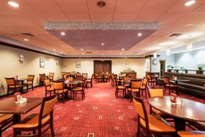 a dining room with wooden tables and chairs at Crowne Plaza Newark Airport by IHG in Elizabeth