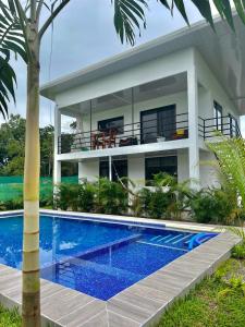 a house with a swimming pool in front of a house at Oso Perezoso Pool Villa in Puerto Viejo