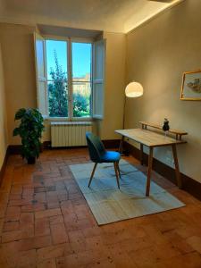 シエナにあるCasa Baldiのテーブルと椅子、窓が備わる客室です。