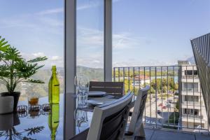 a dining room table with a view of a city at LE TRESUM - Garage, Balcon & Vue lac! in Annecy