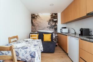a kitchen with a table and a couch in a room at Canastro do Vidoeiro in Vieira do Minho