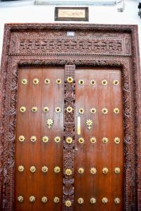 une grande porte en bois ornée de décorations dorées. dans l'établissement Minara Miwili - Forodhani Park, à Zanzibar City