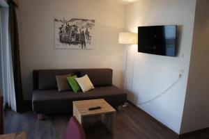 sala de estar con sofá y TV de pantalla plana en Apart Alpin, en Lermoos