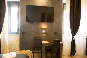 Habitación con mesa y TV en la pared. en Jadore Monic, en Roma