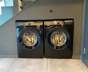 duas máquinas de lavar roupa sentadas uma ao lado da outra num quarto em Luxury Apartments Keszthely em Keszthely