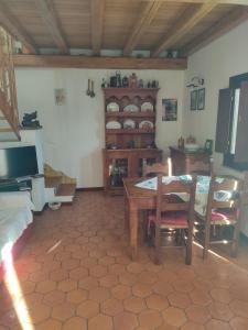 sala de estar con mesa y TV en Antica Casa dei Contadini di Orosei, en Orosei