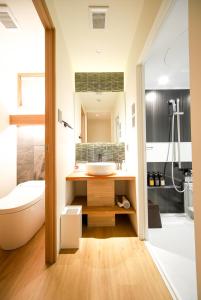 a bathroom with a sink and a toilet and a tub at Riri Kyoto in Kyoto