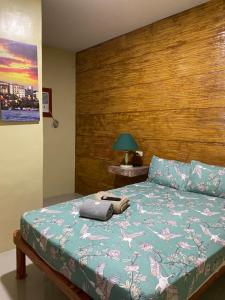 a bedroom with a bed with a wooden headboard at RedDoorz @ Piamonte Apartelle Santo Tomas Batangas in Santo Tomas
