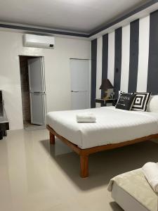 a bedroom with a bed and a striped wall at RedDoorz @ Piamonte Apartelle Santo Tomas Batangas in Santo Tomas +17 photos