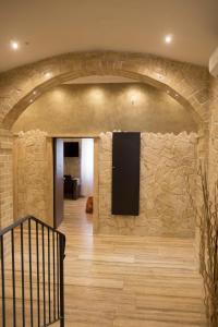 Cette chambre est dotée d'un mur en pierre et d'une télévision murale. dans l'établissement Jadore Monic, à Rome