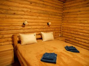 a bedroom with a bed in a log cabin at Rodovoe Gnezdo Garmaki in Garmaki