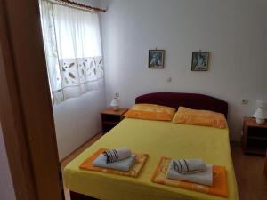 una camera con un letto giallo e due asciugamani di Apartmani Jereb a Drasnice
