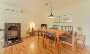 a dining room with a table and a fireplace at Authentic Cabin - Unique location - In nature - 2BR in Hellur