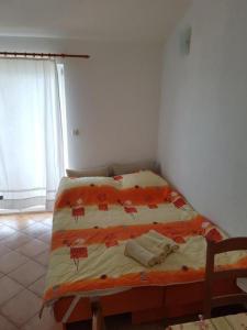 una camera da letto con un letto e un piumone arancione di Apartmani Jereb a Drasnice
