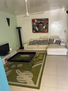 - un salon avec deux canapés blancs et une télévision dans l'établissement Appartement "AMINA" mit Pool, à Saly Portudal