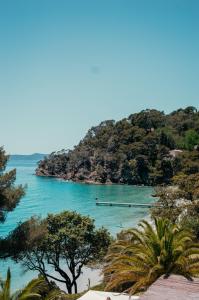 a view of a beach with a boat in the water at La Résidence du Bailli in Rayol-Canadel-sur-Mer