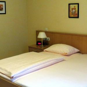 a bedroom with a bed and a lamp on a table at Hotel Saar in Kusel