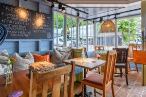 un restaurant avec des tables, des chaises et un tableau noir dans l'établissement The Running Horse, à Winchester