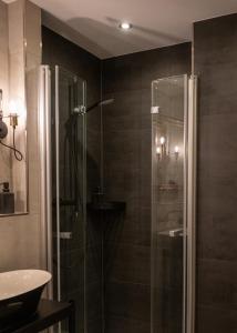 uma casa de banho com uma cabina de duche em vidro e um lavatório. em Haus Hohenstein em Witten