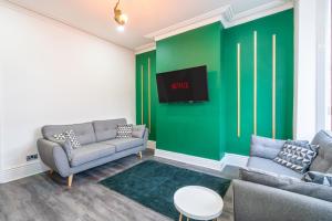 a living room with two couches and a green wall at Stylish 3 Bed - Entire House- Near City Ctr & SUFC in Sheffield