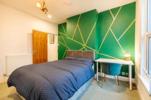 a bedroom with a bed and a green wall at Stylish 3 Bed - Entire House- Near City Ctr & SUFC in Sheffield
