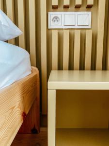 a bed with a wooden headboard and a wooden headboard at Colors Apartments in Zator