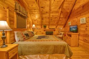 ein Schlafzimmer mit einem Bett in einem Blockhaus in der Unterkunft Buddy Bear #249 in Pigeon Forge