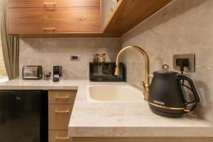 a kitchen with a sink and a tea kettle on a counter at kadarim Boutique Suites-beachfront Zimmer in Haifa