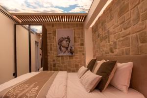a bedroom with a stone wall and a bed at kadarim Boutique Suites-beachfront Zimmer in Haifa