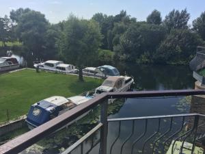 a group of boats parked next to a river at Whitehouse Holiday Lettings - Luxury Serviced Properties in St Neots, Little Paxton and Great Paxton in Saint Neots