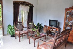 een woonkamer met 2 stoelen en een televisie bij Homestay Orchid in Mahawatta