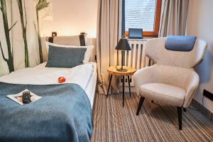 ヴァルデックにあるFlair Hotel Werbetalのベッドと椅子付きのホテルルーム
