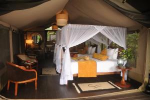 ein Schlafzimmer mit einem Bett in einem Zelt in der Unterkunft Castel Mara Camp in Masai Mara