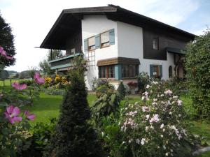 una gran casa blanca con flores delante en Ferienwohnung Edmeier, en Bernau am Chiemsee