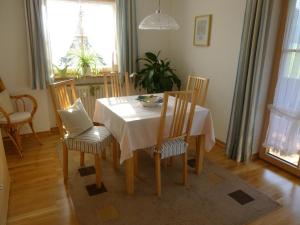 comedor con mesa blanca y sillas en Ferienwohnung Edmeier, en Bernau am Chiemsee