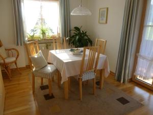 a dining room with a white table and chairs at Ferienwohnung Edmeier in Bernau am Chiemsee