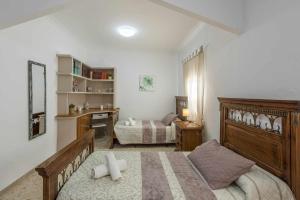 un dormitorio con una cama y un escritorio en Casa rural Entre Olivos, en La Puebla de Cazalla 42 fotos más
