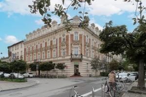 une femme faisant du vélo devant un bâtiment dans l'établissement Perła Starego Miasta Kamienica Czapskich by Noclegi Renters, à Cracovie