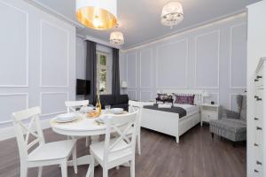 - une salle à manger et un salon avec une table et un lit dans l'établissement Perła Starego Miasta Kamienica Czapskich by Noclegi Renters, à Cracovie 7 autres photos