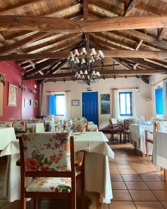 un comedor con mesas y sillas blancas en Aldea Couso Rural en Sarreaus