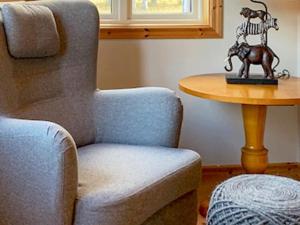 una habitación con una silla y una mesa con una estatua de un caballo en 5 person holiday home in HAGFORS en Hagfors