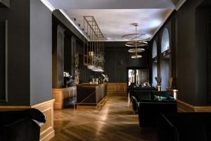 a lobby with black walls and a bar with chairs at Dwór Sanna in Wierzchowiska