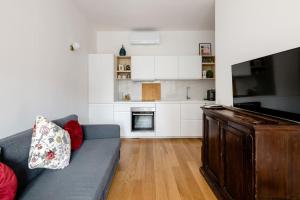 a living room with a couch and a kitchen at Ripa Apartments Milano - Pastorelli in Milan