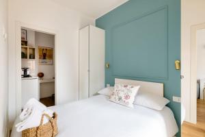 a bedroom with a white bed and a blue wall at Ripa Apartments Milano - Pastorelli in Milan