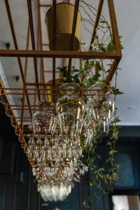 a bunch of wine glasses hanging from a chandelier at Dwór Sanna in Wierzchowiska